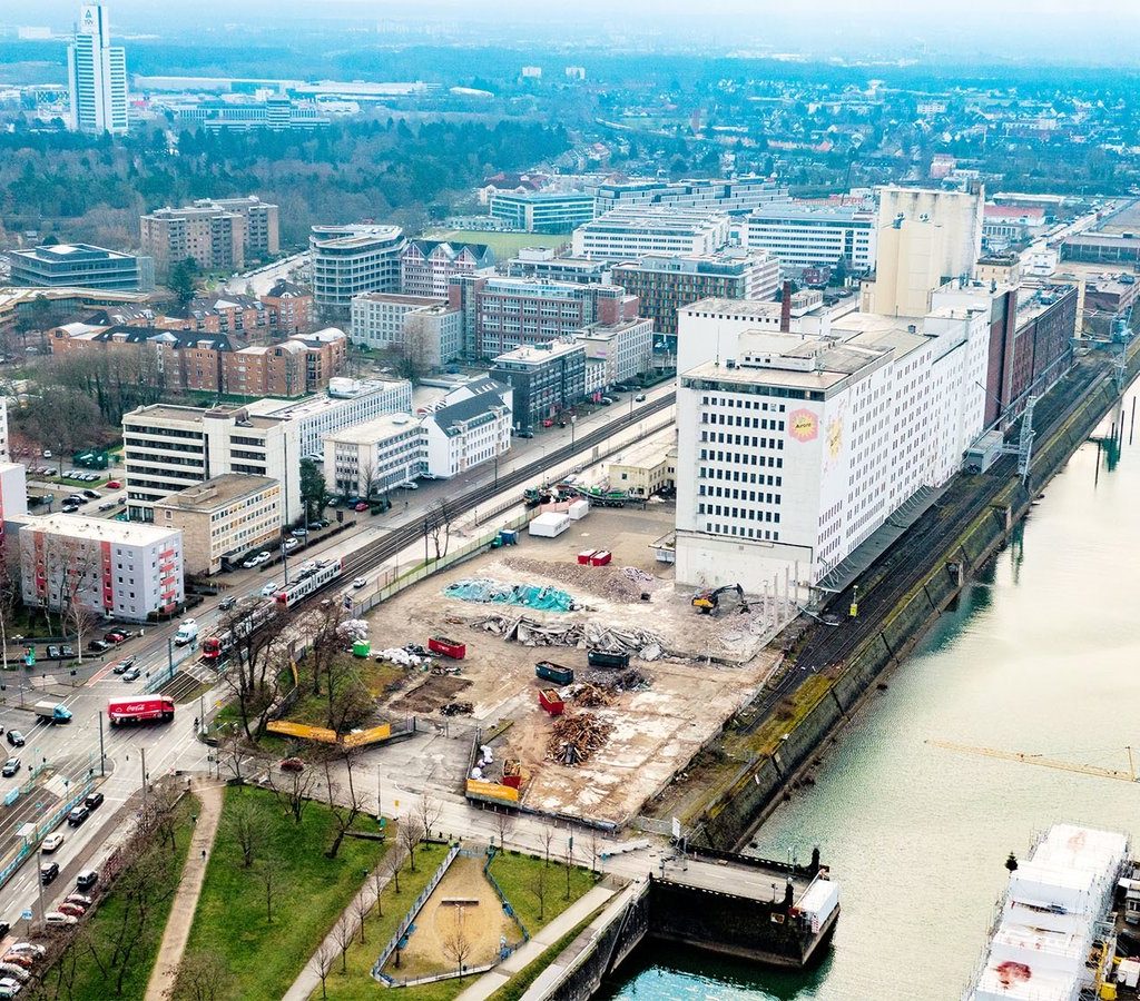 Luftaufnahme vom Deutzer Hafen Köln mit Entkernung der Auermühle, Abrissfläche und Bauarbeiten entlang des Hafenbeckens.