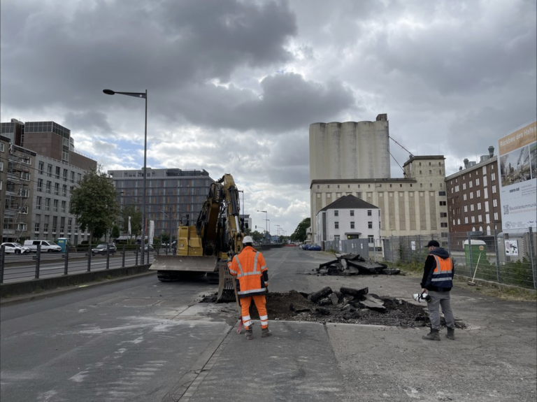 Kanalbauarbeiten in der Mühlenstraße im Deutzer Hafen Köln mit Bagger und Baustellenpersonal.