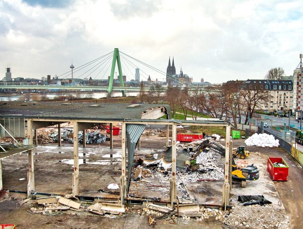 Entkernung der Auermühle im Deutzer Hafen Köln gestartet, teilweise abgetragene Industriehalle mit Blick auf Severinsbrücke und Kölner Dom.