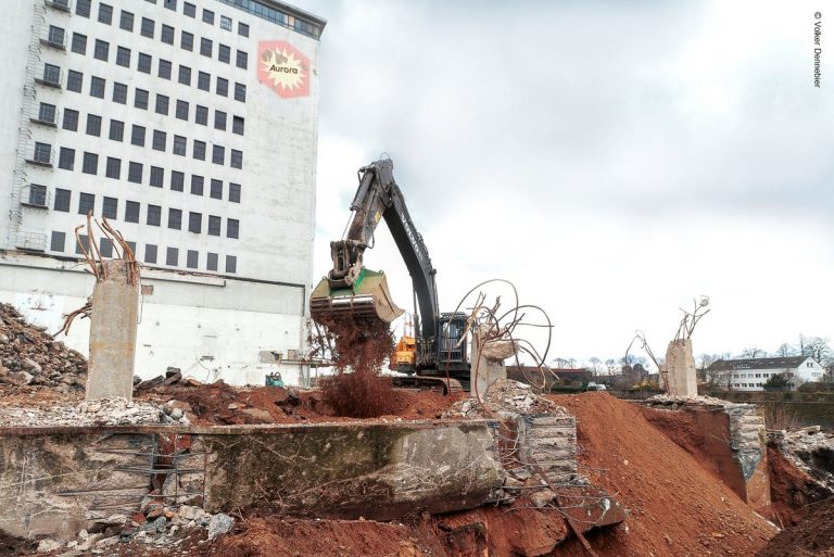 Bagger beim Rückbau der Bodenplatte der ehemaligen Absackhalle im Deutzer Hafen Köln.