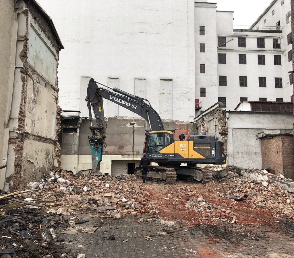 Bagger bei der Niederlegung des Verwaltungsgebäudes und des Kesselhauses im Deutzer Hafen Köln, umgeben von Bauschutt.