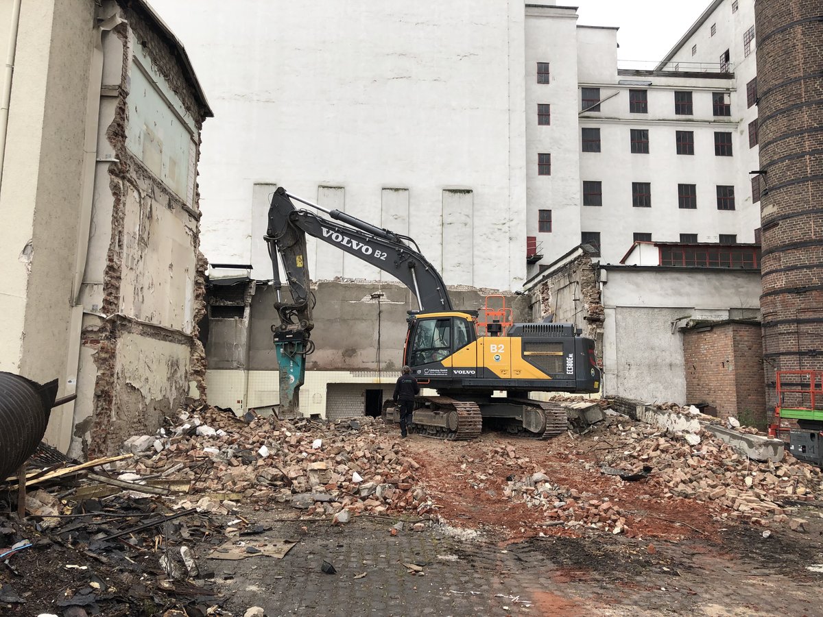 Bagger bei der Niederlegung des Verwaltungsgebäudes und des Kesselhauses im Deutzer Hafen Köln, umgeben von Bauschutt.
