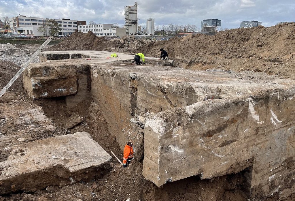 Freigelegte Bunkerfundamente auf dem Gelände des Deutzer Hafens Köln, mehrere Personen untersuchen die Betonstrukturen.