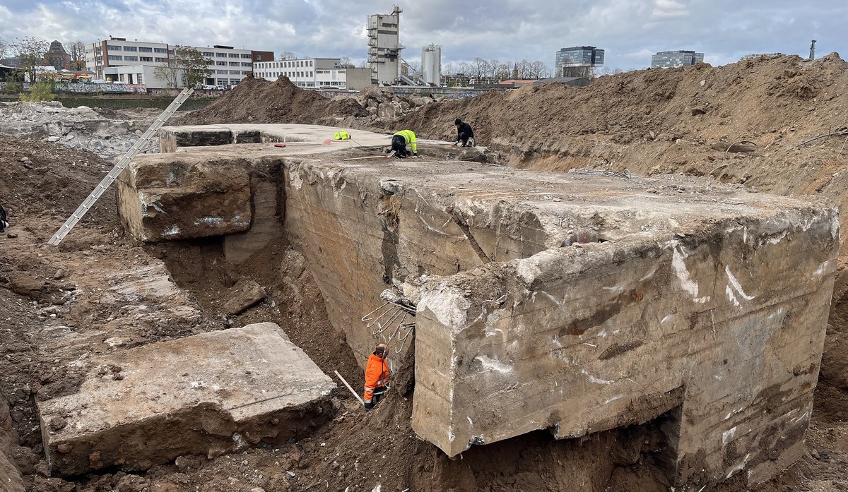 Freigelegte Bunkerfundamente auf dem Gelände des Deutzer Hafens Köln, mehrere Personen untersuchen die Betonstrukturen.