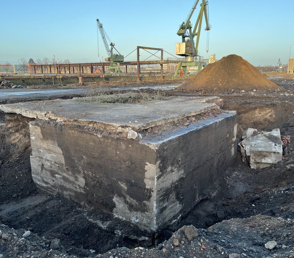 Freigelegtes Bunkerfundament auf dem Gelände des Deutzer Hafens Köln mit Hafenkränen im Hintergrund.