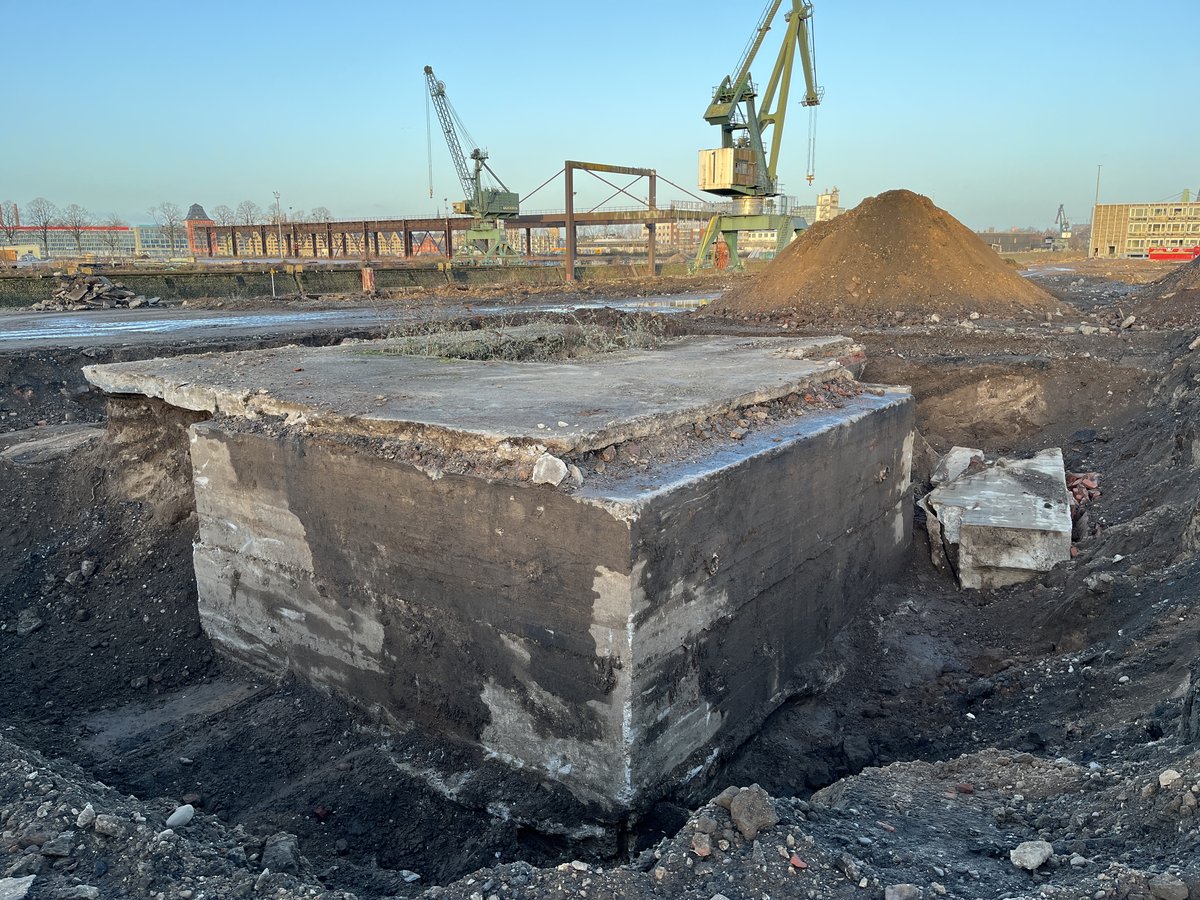 Freigelegtes Bunkerfundament auf dem Gelände des Deutzer Hafens Köln mit Hafenkränen im Hintergrund.