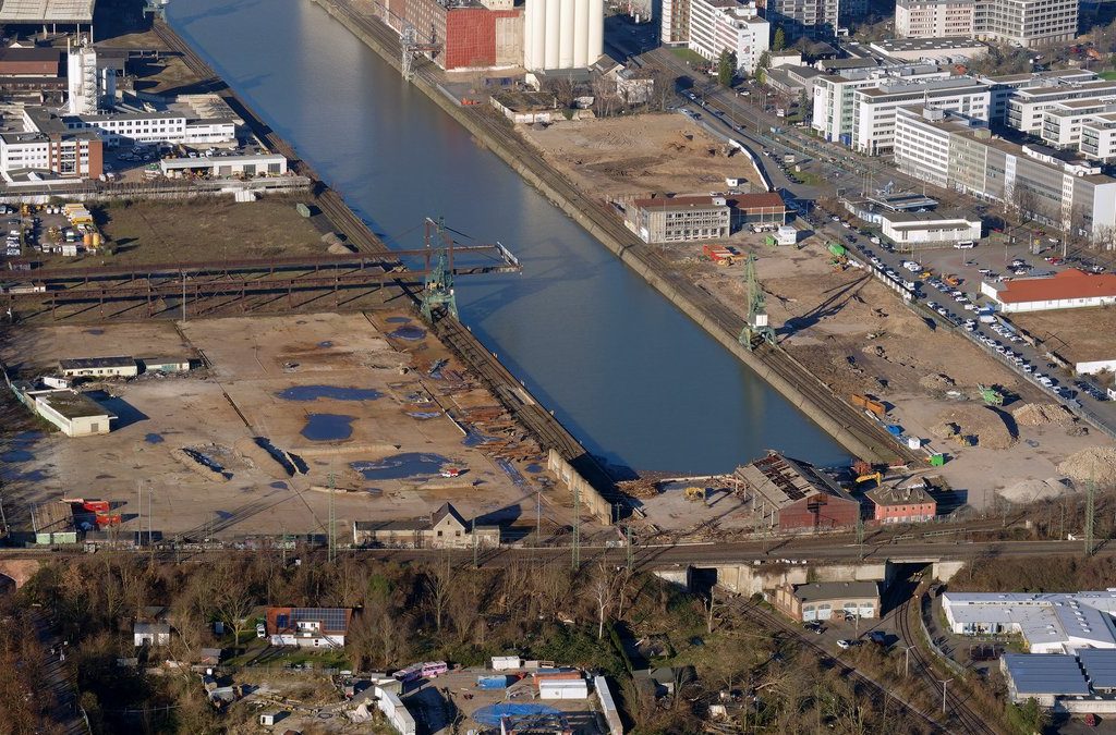 Luftbild des Deutzer Hafens Köln mit Hafenbecken, Kränen und freigeräumten Flächen für die Quartiersentwicklung.