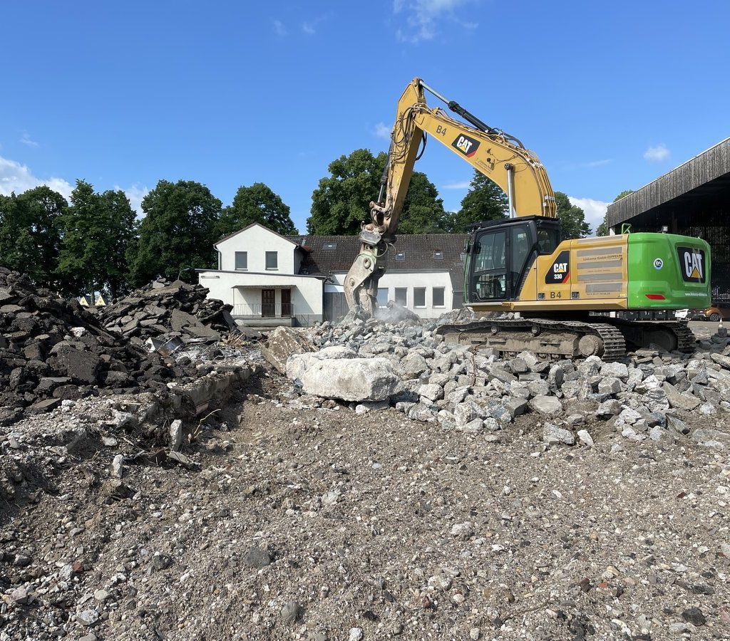 Bagger zerkleinert Betonreste beim Rückbau auf einer Fläche im Deutzer Hafen Köln.